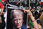 Manifestantes de la comunidad iraní en Los Ángeles, California, ondea banderas y pancartas con la imagen de Trump en apoyo a  los ataques contra Irán.