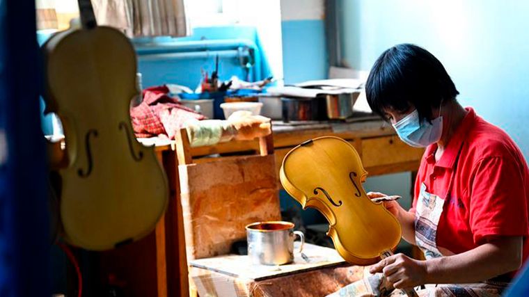 Un trabajador fabrica un violín en un taller de Queshan, en la provincia china de Henan. Un trabajador fabrica un violín en un taller de Queshan, en la provincia china de Henan.