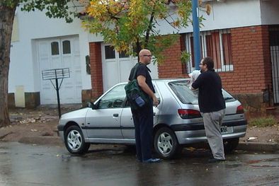 MDZol | Un vecino de Godoy Cruz comenta la granizada mientras acaba de retirar un cobertor que puso de emergencia sobre su vehículo. Foto: Atahualpa Acosta
