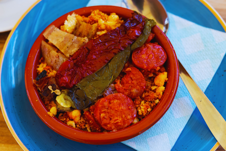 La receta de migas tiene orígenes pastoriles y se preparaba como una forma de aprovechar el pan duro en los largos días de trabajo en el campo.