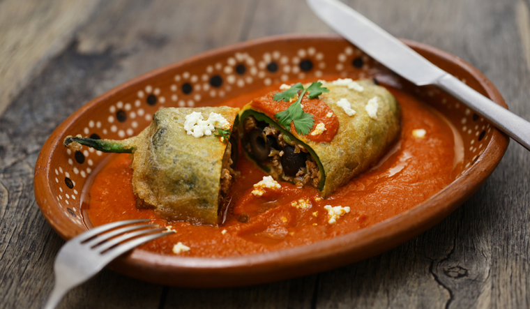 La receta de chiles rellenos de picadillo combina ingredientes prehisp&aacute;nicos, como el chile poblano, con influencias espa&ntilde;olas como las pasas y almendras, creando un platillo mestizo muy representativo de M&eacute;xico.