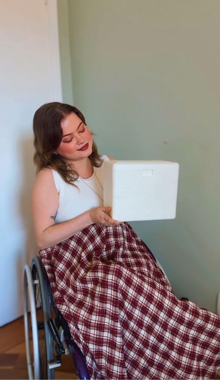Maria Paula sosteniendo la primera caja de medicamentos para el tratamiento.