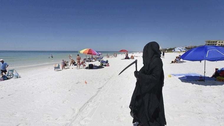 El abogado Daniel Uhlfelder, vestido en un traje de la muerte, camina por una playa recién abierta en Florida, EE.UU., el 1 de mayo de 2020.