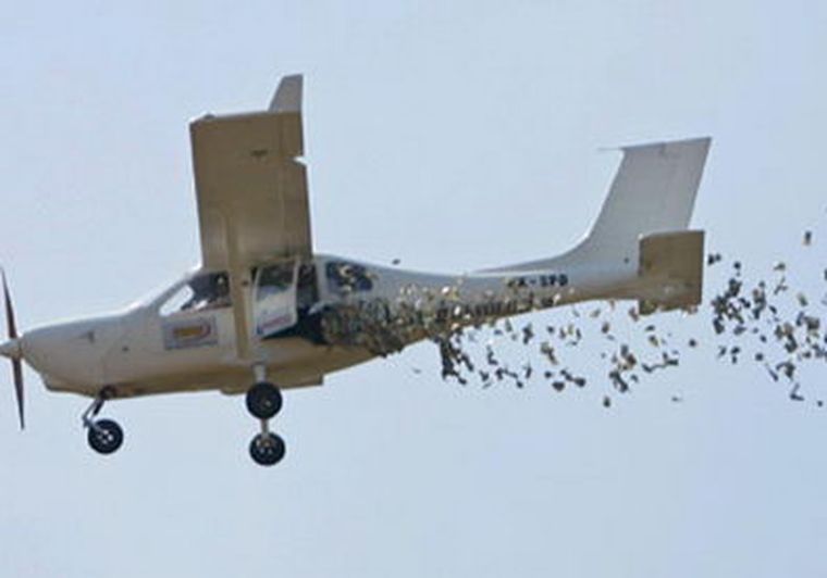 Una avioneta reparte dinero sobre la población de Yakarta. Foto: AP