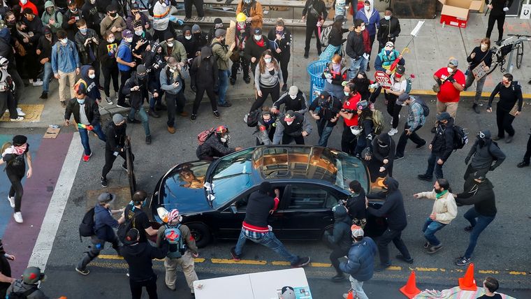 Un hombre trata de abrir el coche de una persona que lo dirigió hacia una multitud durante las protestas en Seattle, EE.UU., el 7 de junio de 2020.