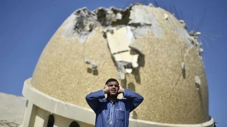Un hombre reza frente a una mezquita destruida por los bombardeos de Israel en Gaza. Foto: BBC