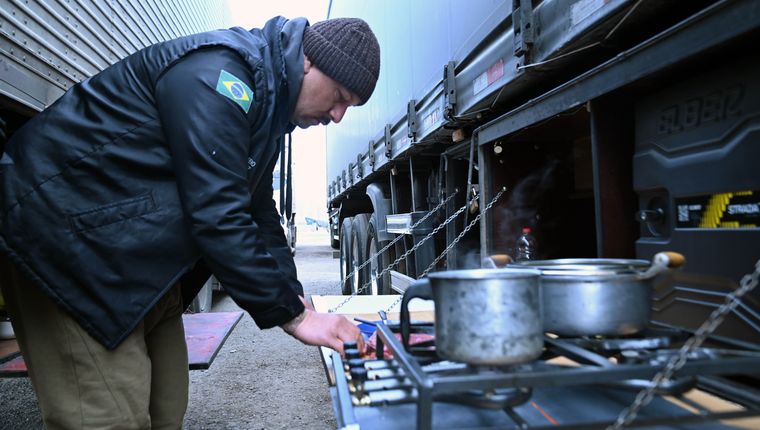 Los camioneros pasan semanas dentro de sus vehículos y deben organizar allí sus comidas mientras esperan la apertura del paso.