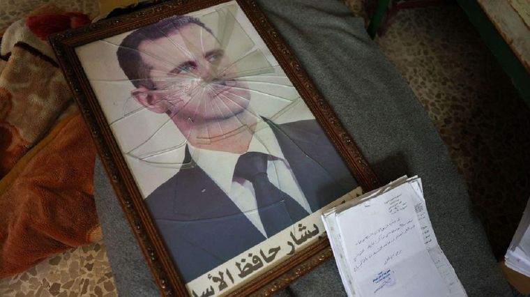Un retrato roto y en el suelo de Bashar al Assad Foto: BBC