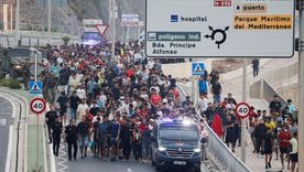 Agentes de policía y soldados españoles escoltan a un numeroso grupo de migrantes en Ceuta hasta la frontera para devolverlos a Marruecos.