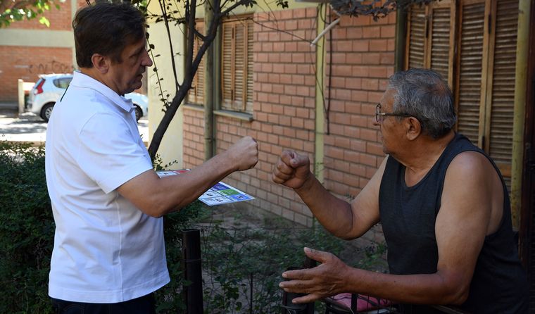 La caminata con un candidato a concejal. Reparte folletos y explica a la gente.&nbsp;