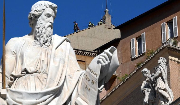 Obreros trabajan instalando la chimenea en el techo de la Capilla Sixtina. Foto: Efe.