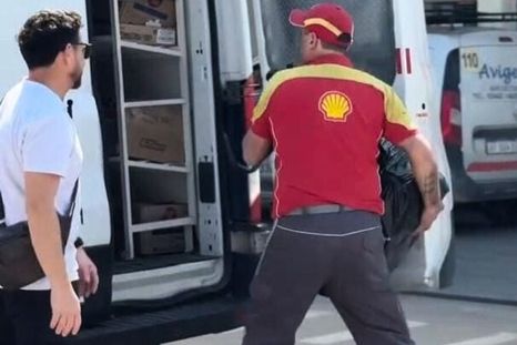 En la publicidad misógina de las estaciones de servicio se ve a un hombre metiendo a una mujer en una bolsa negra en una camioneta. En la publicidad misógina de las estaciones de servicio se ve a un hombre metiendo a una mujer en una bolsa negra en una camioneta.