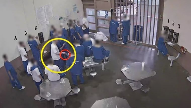 El momento en que uno de los presos le pasa el vaso a otro