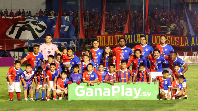 Los jugadores de FAS posan con sus hijos y niños de categorías inferiores antes de su partido contra Municipal Limeño. Es uno de los tres equipos de Primera División que han comenzado a usar los dorsales 13 o 18.