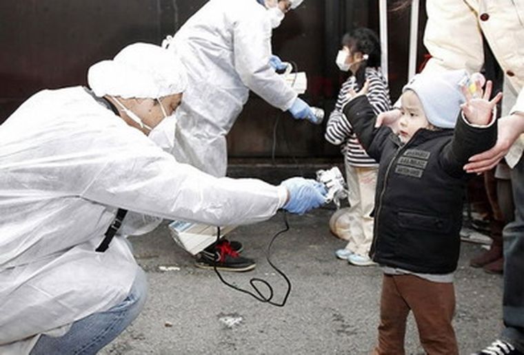 Una niña es chequeada por técnicos en las cercanías del desastre nuclear.