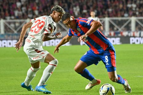 Manuel Insaurralde (8), mediocampista de San Lorenzo, deja en el camino a Fabricio Pérez (29), jugador de Estudiantes.