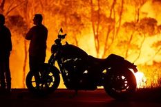 El cielo se enrojeció y oscureció varias zonas del sudeste de Australia a medida que las ráfagas de viento exacerbaban el fuego, en una de las peores temporadas de incendios forestales en el país. Aquí, un par de residentes de Tabourie Lake, a unos 200 kilómetros al sur de Sídney, observan cómo las llamas se devoran un bosque.