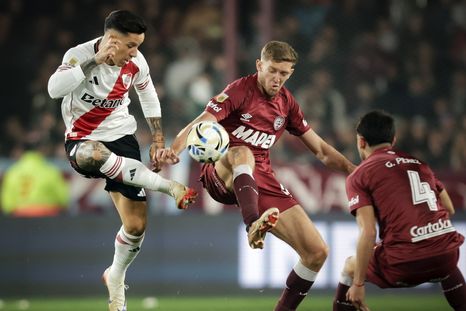El Granadero Castillo, autor del agónico empate de Lanús, disputa el balón con Sebastián Dirussi, quien ingresó en el ST por Colidio.