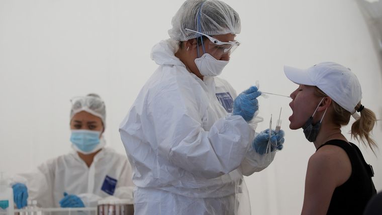 Una trabajadora sanitaria toma un hisopo de una mujer en una estación de pruebas móvil en Almatý, Kazajistán, el 17 de junio de 2020.