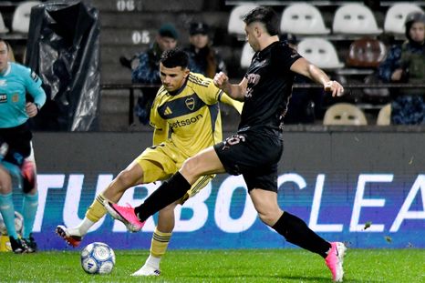 Leonel Flores desborda y saca el centro ante la marca de un defensor de Platense.
