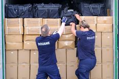 Agentes de aduanas buscan drogas en un contenedor el 11 de julio de 2023 en el puerto de Amberes, Bélgica. Cada vez más cocaína procedente de Sudamérica llega a este puerto belga.