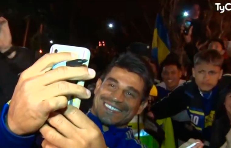 Ibarra, con una sonrisa de oreja a oreja, tomándose selfies con los hinchas que fueron a la puerta del hotel.