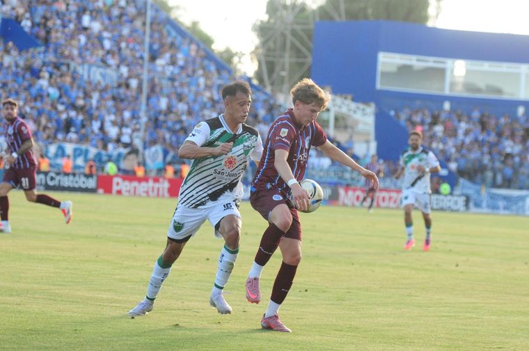 Santino Andino cubre el balón ante la marca de un defensor de San Martín de San Juan.