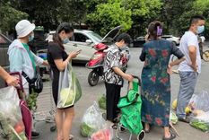 Vecinos hacen cola para comprar verdura antes de que empiece el confinamiento en Chengdu. Foto: GETTY IMAGES