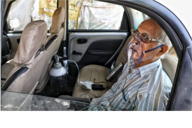 Sushil Kumar Srivastava fue fotografiado en su auto, conectado a una botella de oxígeno en la ciudad de Lucknow. Foto: SUMIT KUMAR