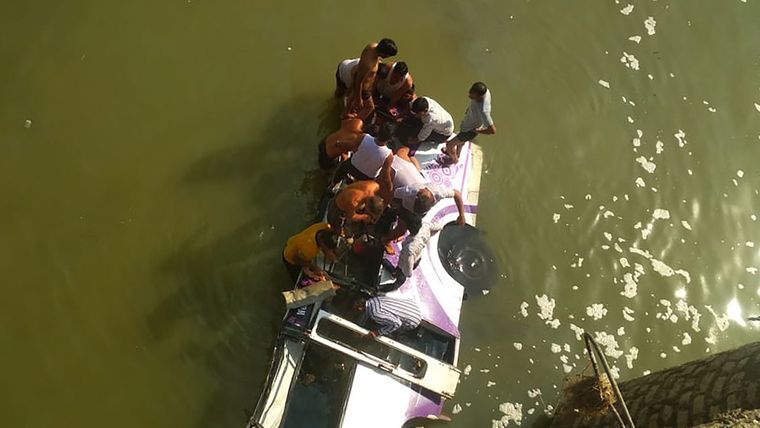 Rescatistas buscan sobrevivientes en un autobús que se cayó a un río en el noroeste de la India el 26 de febrero de 2020.
