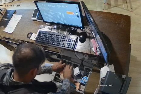 El delincuente violentando la caja recaudadora del Go Bar de la Quinta Sección. Foto: captura de video.