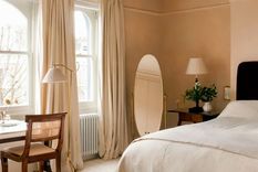 La diseñadora de interiores&nbsp;Jessica Summer&nbsp;creó un color de pintura personalizado para este sereno dormitorio, optando por un tono entre rosa y beige que adorna delicadamente las paredes de la habitación.