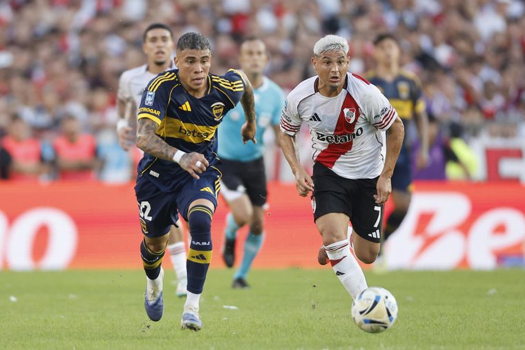 Maxi Salas, de River, y Ayrton Costa, de Boca, corren en busca de la pelota.