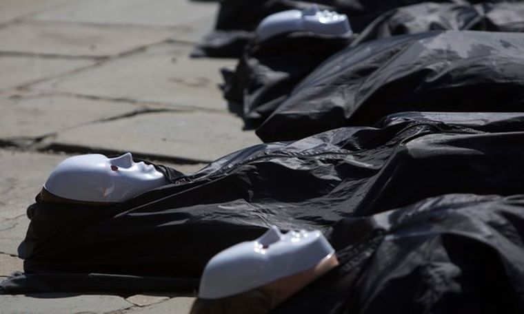 Miembros de Control Arms Coalition simulan ser cadáveres en bolsas. Foto: reuters