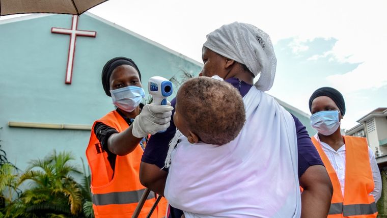 Miembros de una iglesia miden la temperatura a una feligresa en Dar es Salaam (Tanzania).