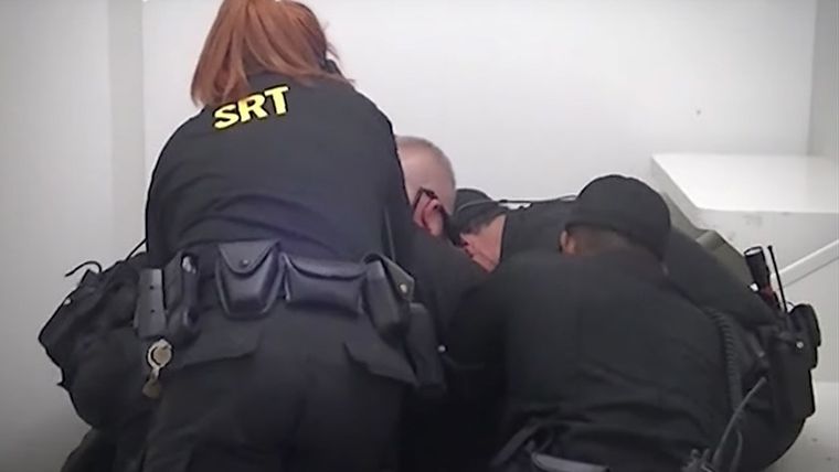 John Neville siendo inmovilizado por guardias de la cárcel de Forsyth.