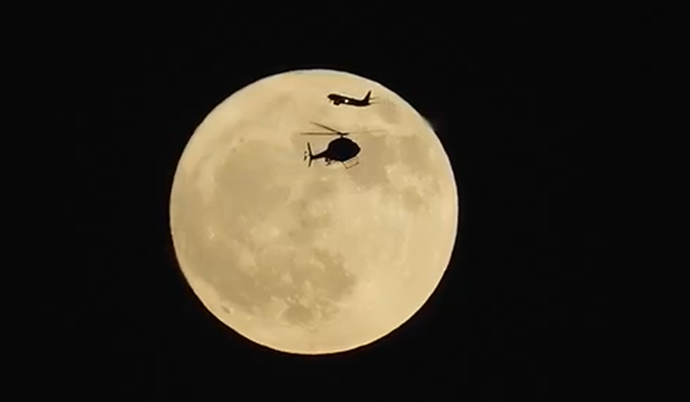 El cruce del avión y el helicóptero frente a la Luna registrado por el fotógrafo Craig Shimala.