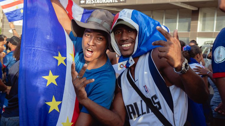 La bandera de Cabo Verde, adoptada en 1992, muestra franjas azules, blancas y rojas que simbolizan el océano, la paz y el esfuerzo nacional. El círculo de diez estrellas representa las islas principales y su unidad como nación.