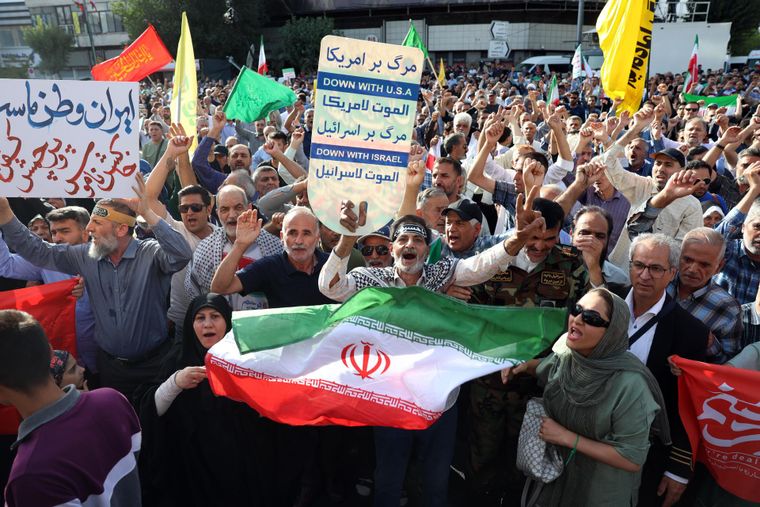 Los iraníes ondean banderas nacionales durante una manifestación contra Estados Unidos y contra Israel en Teherán.
