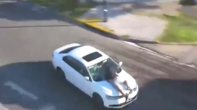 Colgado de un capot Foto: captura de video