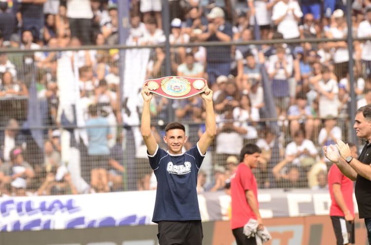 Ayrton Giménez, campeón del título Latino de la OMB en la categoría superpluma, con su cinturón y una remera de Gimnasia.