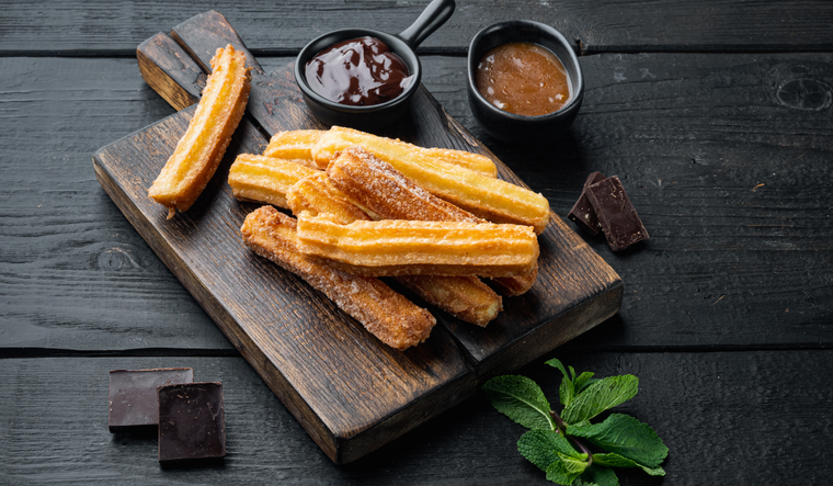 La forma alargada y estriada de los churros se logra usando una manga pastelera con boquilla estrellada, lo que también ayuda a que queden más crujientes. ¡A disfrutar esta receta!