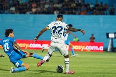 Sebastián Villa intenta sacar el remate ante la marca de Ciro Rosané, quien va al piso intentando bloquear.