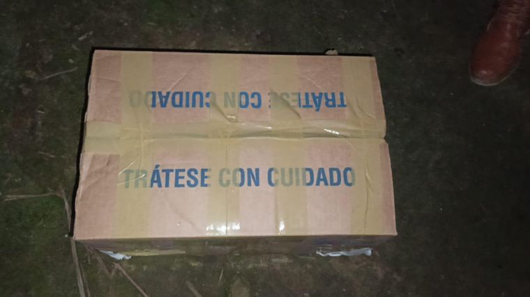 La caja de cartón cerrada con cinta y con un mensaje en azul que dice "Trátese con cuidado".