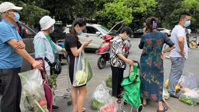 Vecinos hacen cola para comprar verdura antes de que empiece el confinamiento en Chengdu. Foto: GETTY IMAGES