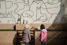 Dos niñas juegan con un gato en el café Museo del Gato Persa en Teherán. Foto: EFE