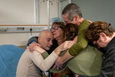 Luis Norberto Har (izquierda) y Fernando Marman (con camiseta verde y cabello gris) abrazan a varios familiares tras su rescate. Foto: Reuters