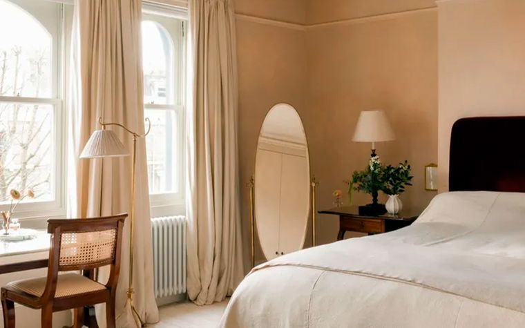 La diseñadora de interiores&nbsp;Jessica Summer&nbsp;creó un color de pintura personalizado para este sereno dormitorio, optando por un tono entre rosa y beige que adorna delicadamente las paredes de la habitación.