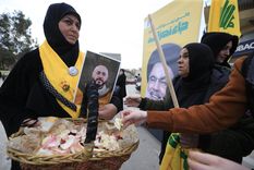 La gente arroja pétalos de flores a carteles de combatientes fallecidos de Hezbolá, al regresar a su ciudad en el sur del Líbano. Foto: EFE