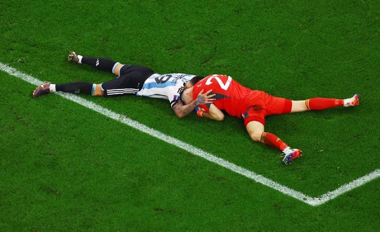Otamendi y el Dibu, abrazados en el césped.